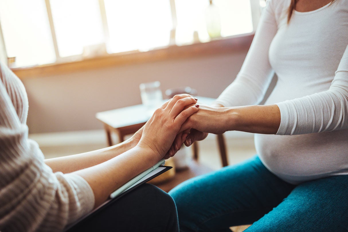 Woman with counselor holding hands