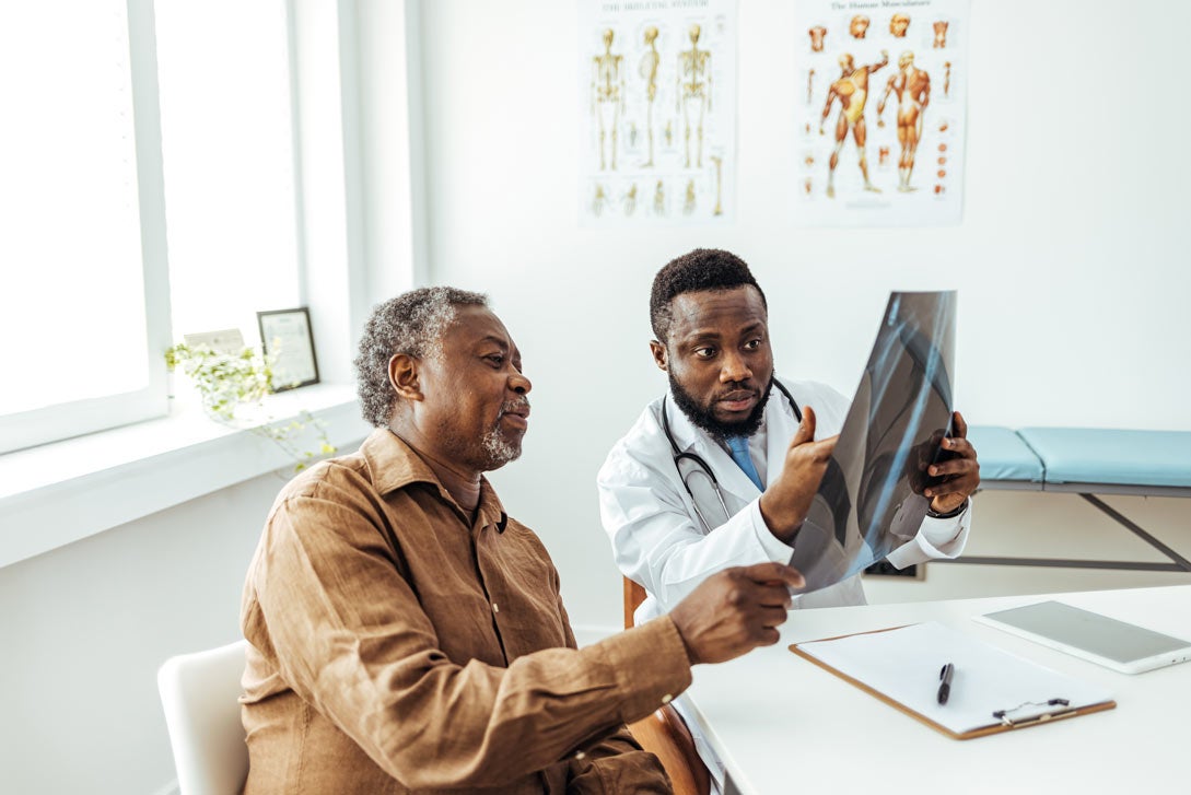Doctor and man looking at lung x-rays